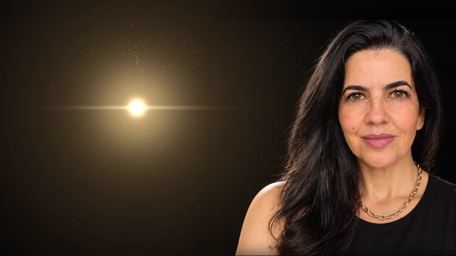 Retrato de Luciana Carvalho à direita, sobre fundo escuro, olhando para a câmera com um leve sorriso; ao lado dela, à esquerda, brilha uma luz dourada suave.